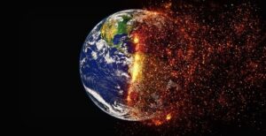 A digital illustration of Earth with its left side showing the planet normally, while the right side appears to be burning and disintegrating into glowing embers, symbolizing global warming and environmental destruction.